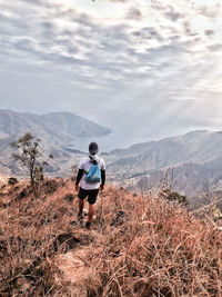 Man looking at mountains against sky