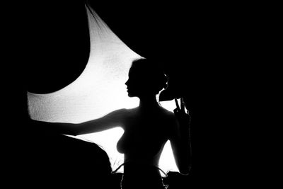 Silhouette woman standing against light