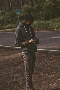 Full length of man photographing while standing on road