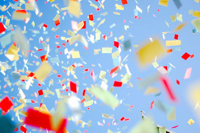 Low angle view of confetti against clear sky