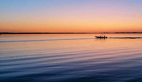 Silhouette boat in sea against sky during sunset