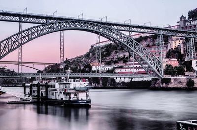 Bridge over river against sky in city