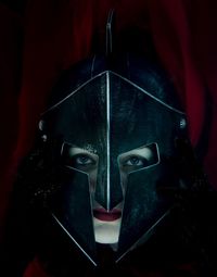 Portrait of woman wearing mask in darkroom