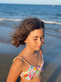 Portrait of smiling young woman looking away at beach