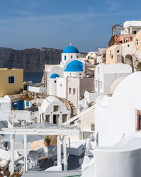 View of oia village in santorini with traditional white houses and blue domes churches, greece