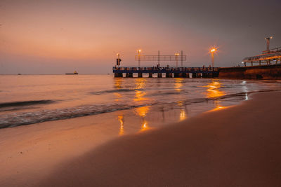 Pier on sea against sky during sunset