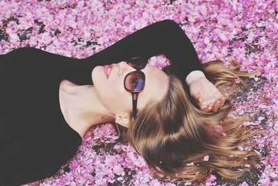 High angle view of woman lying on pink flowers