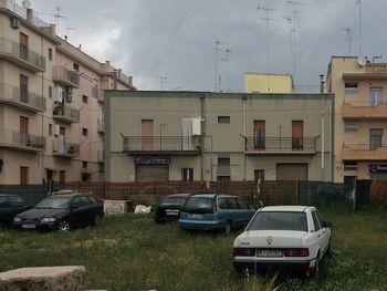 Cars on houses against sky