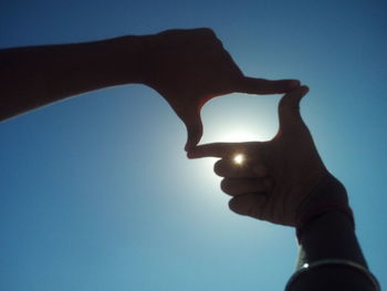 Low angle view of human hand against clear sky