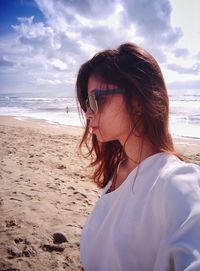 Portrait of woman on beach against sky