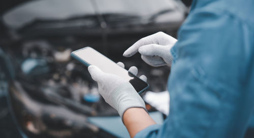 Midsection of man using mobile phone