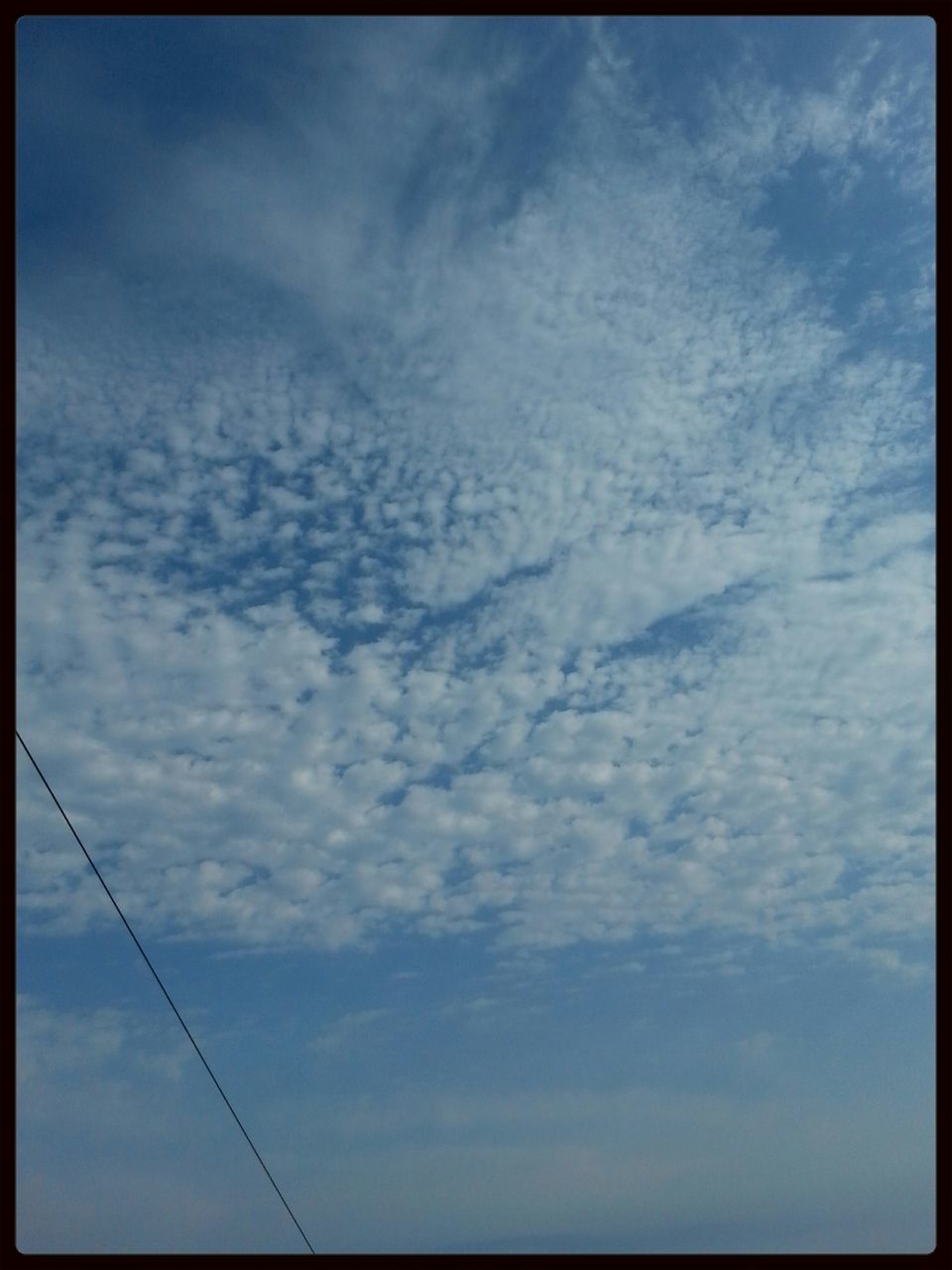 transfer print, sky, low angle view, auto post production filter, cloud - sky, cloudy, cloud, tranquility, beauty in nature, nature, scenics, blue, tranquil scene, outdoors, day, no people, power line, overcast, cloudscape, weather