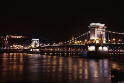 Suspension bridge over river at night