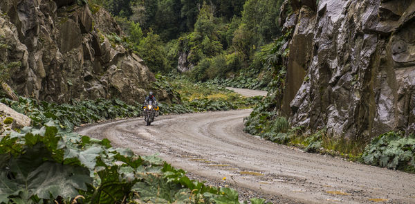Man driving on a touring motorbike gravel road on carretera austral