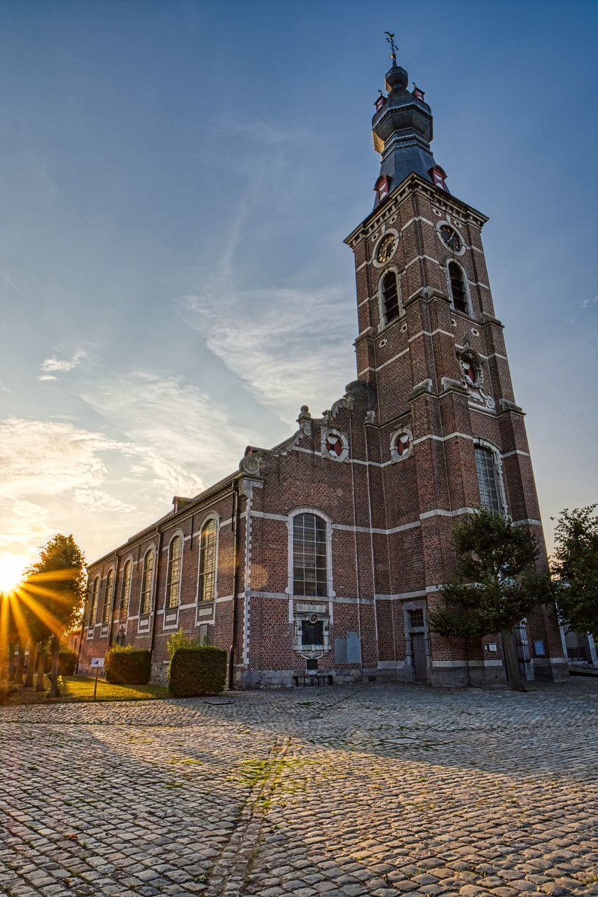 LOW ANGLE VIEW OF CROSS AMIDST BUILDINGS AGAINST SKY