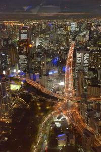 High angle view of illuminated street amidst buildings at night