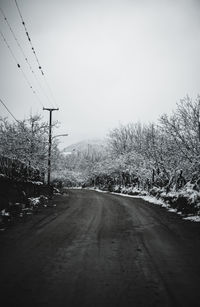 Road amidst trees against clear sky