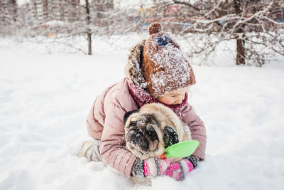 Woman with dog on snow field