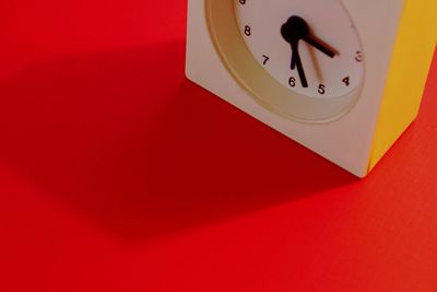 Close-up of clock against red background