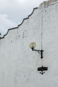 Low angle view of street light against building