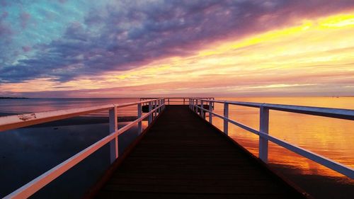 Pier on sea against cloudy sky