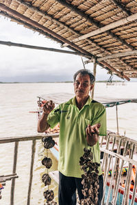 Portrait of man standing by railing