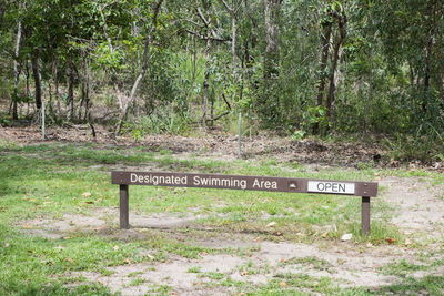 Information sign by trees in forest