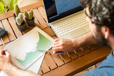 High angle view of man using laptop during trading