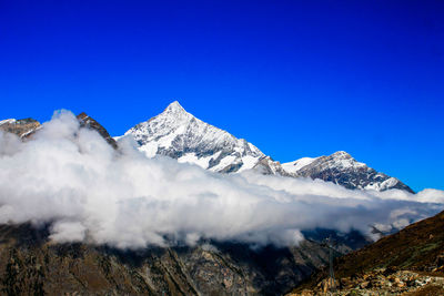 Low angle view of mountains against clear blue sky