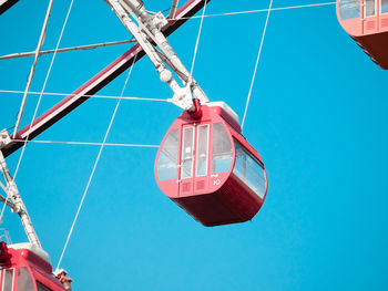 Low angle view of ferris wheel against blue sky