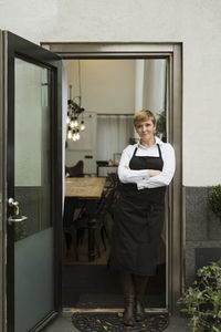 Full length portrait of sommelier standing at workshop entrance