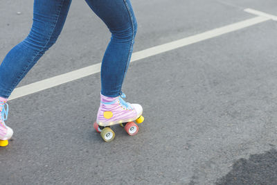 Low section of man skateboarding on road