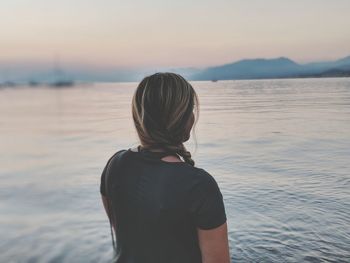 Rear view of woman standing at beach