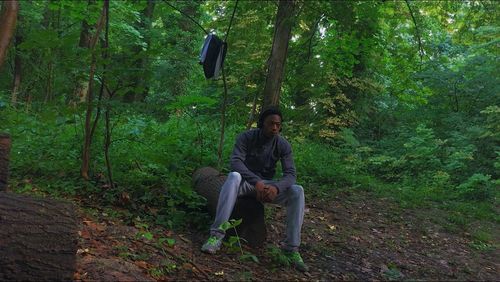 Full length of man sitting in forest