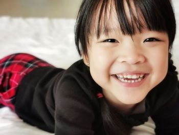 Portrait of cute boy smiling lying on bed