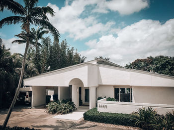 House and palm trees against sky