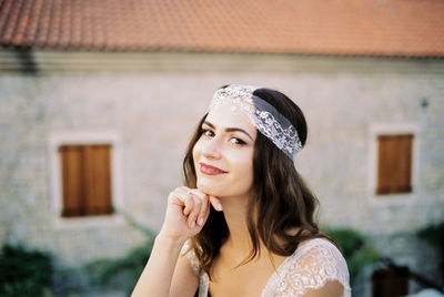 Portrait of young woman standing against trees