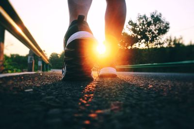 Low section of child on road during sunset