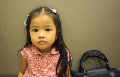 Portrait of cute girl against wall