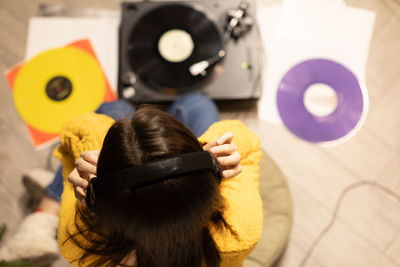 High angle view of woman listening music at home