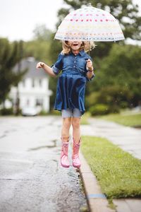 Full length of a girl standing on wet rainy day