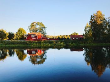 Reflection of building in lake against clear sky