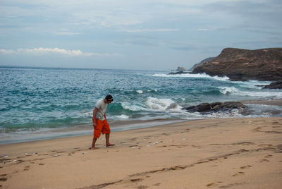 Full length of man on beach against sky