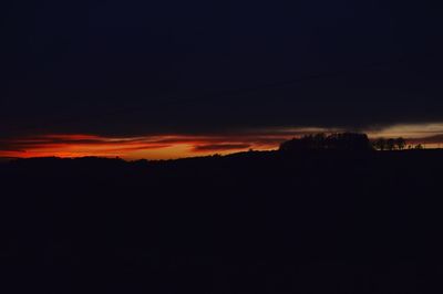 Silhouette landscape against sky at night