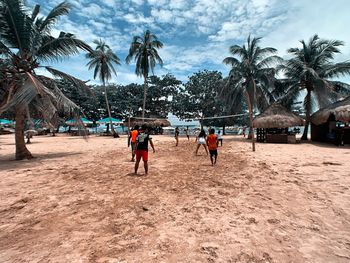 People at beach against sky