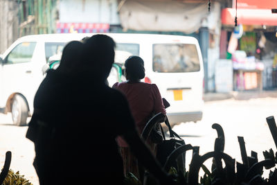 Rear view of people walking on street in city