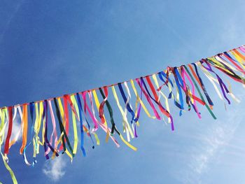 Low angle view of colorful flags hanging against sky