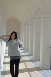 Full length of woman standing in corridor of building