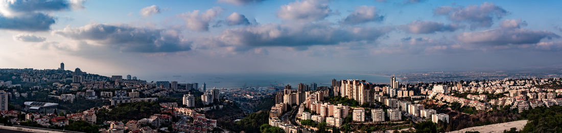 Panoramic view of cityscape against cloudy sky