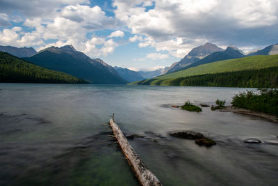 Scenic view of lake by mountains against sky